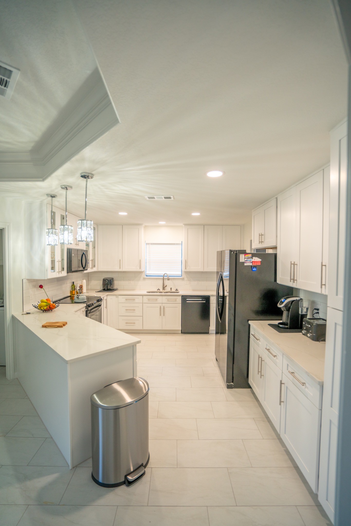 Completed Bedford kitchen remodel with white cabinetry, quartz countertops and subway tile backsplash