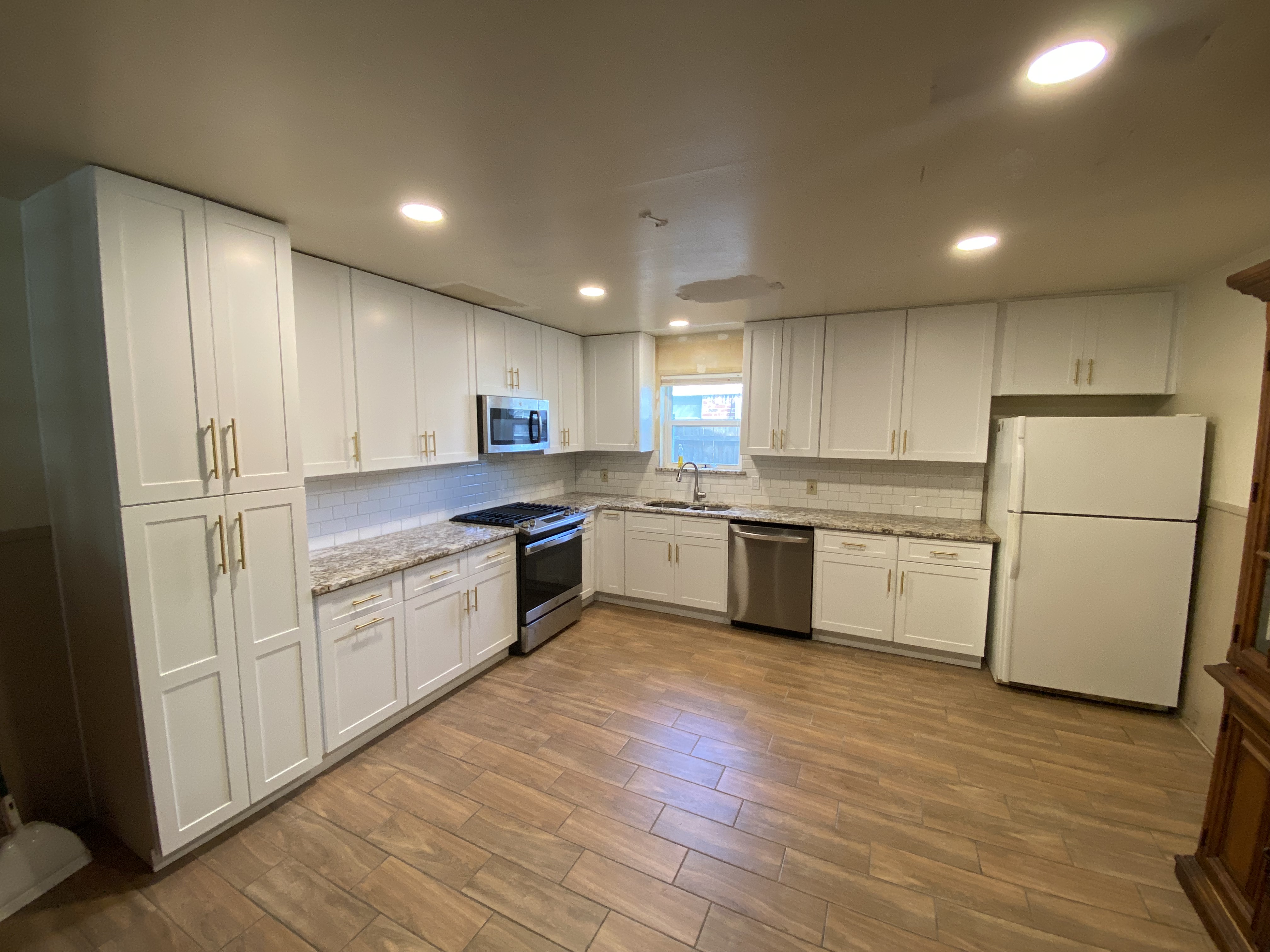Fort Worth kitchen remodel with white shaker cabinets, granite countertops, white tile backsplash and recessed LED lighting