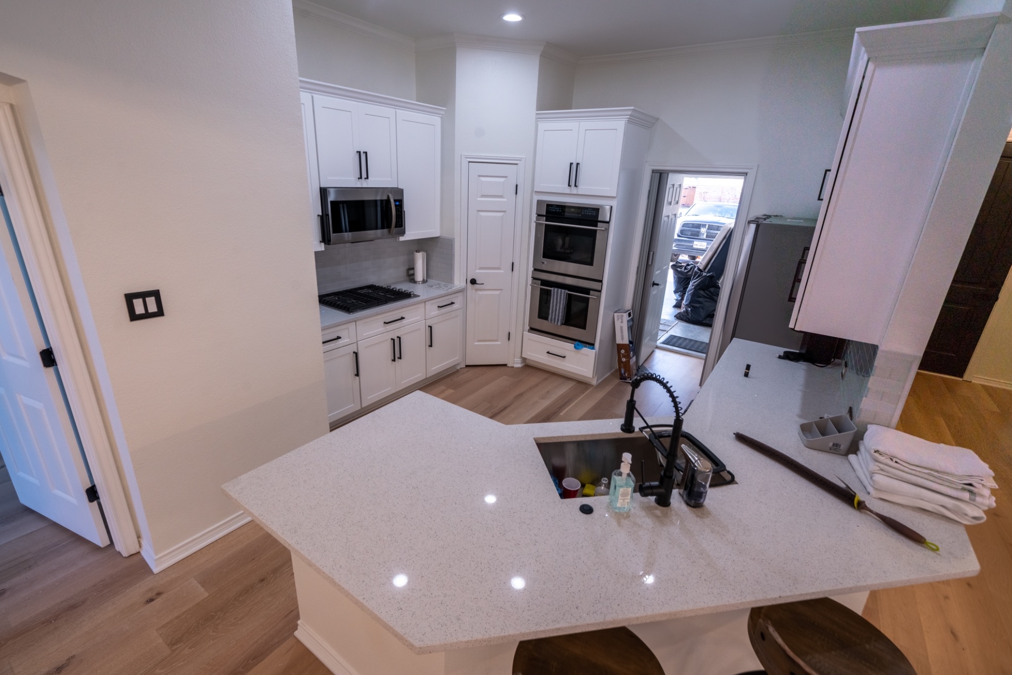 Completed Bedford, Texas full kitchen remodel with white shaker cabinets, quartz countertops, new backsplash, appliances and luxury vinyl flooring
