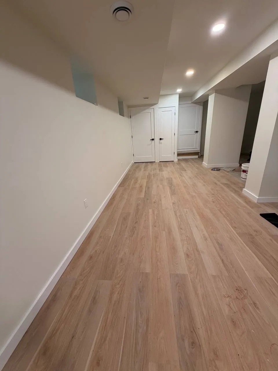 Finished basement remodel with new flooring and recessed lighting