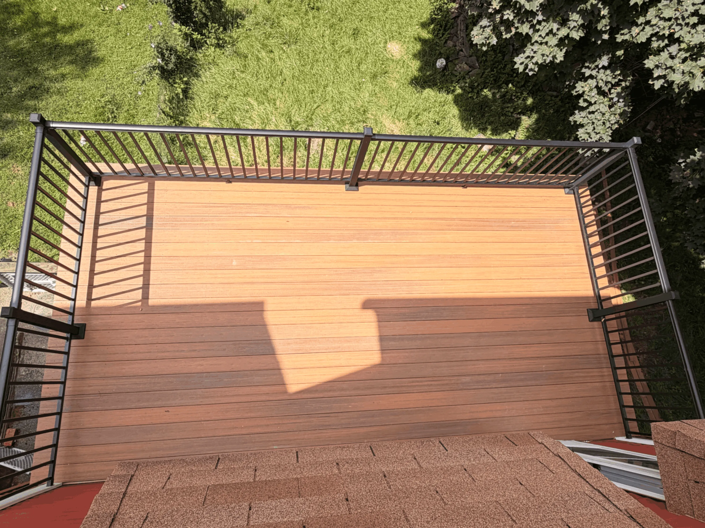 Composite deck with light and dark board banding and black aluminum railings
