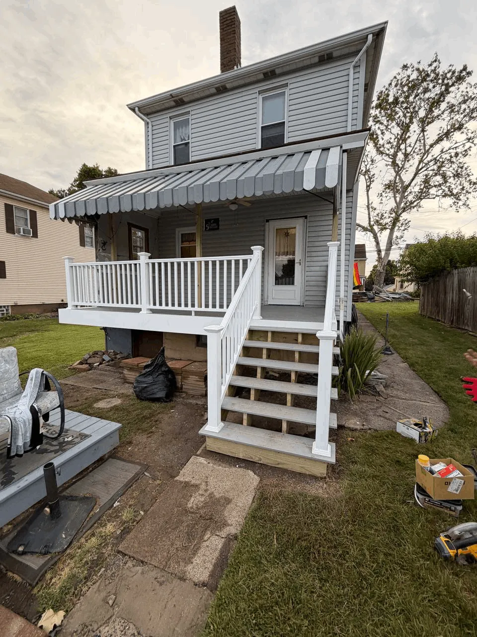 New deck built from the ground up with gray decking and white railings.