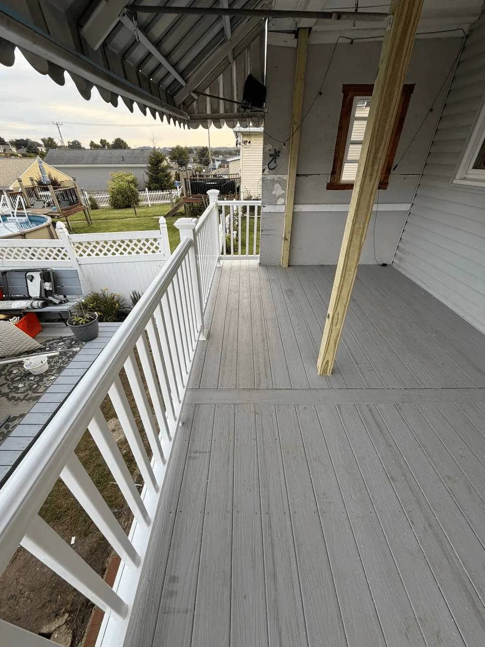 New deck built from the ground up with gray decking and white railings.