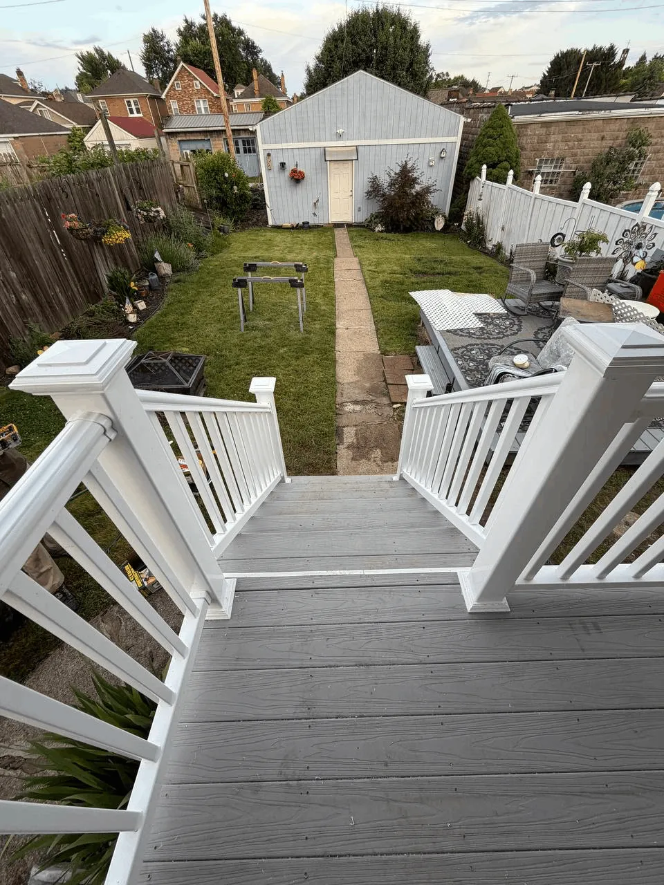 New deck built from the ground up with gray decking and white railings.