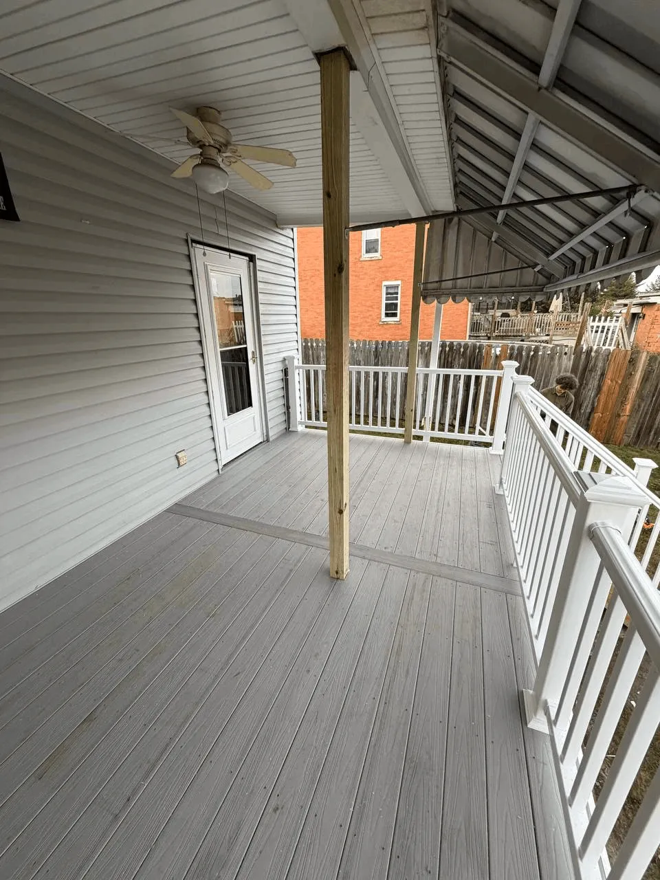 New deck built from the ground up with gray decking and white railings.