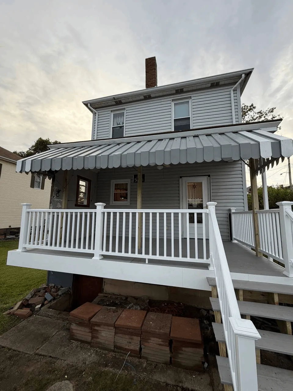 New deck built from the ground up with gray decking and white railings.