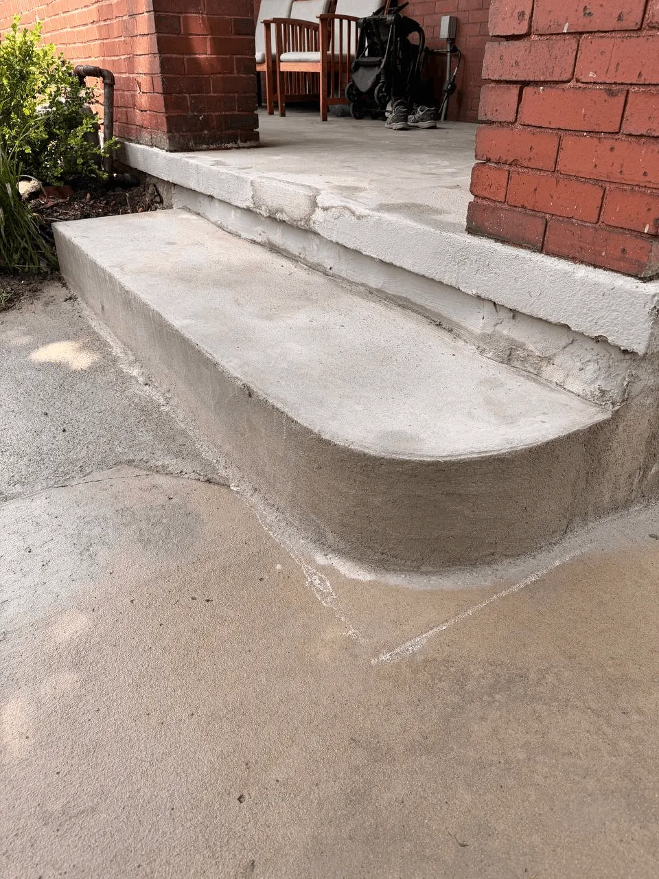 Freshly formed concrete step and landing at a brick building entrance