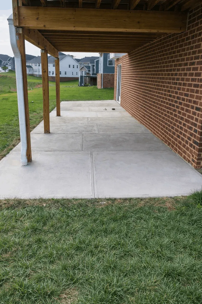 New concrete walkway beside a brick building and covered entry posts