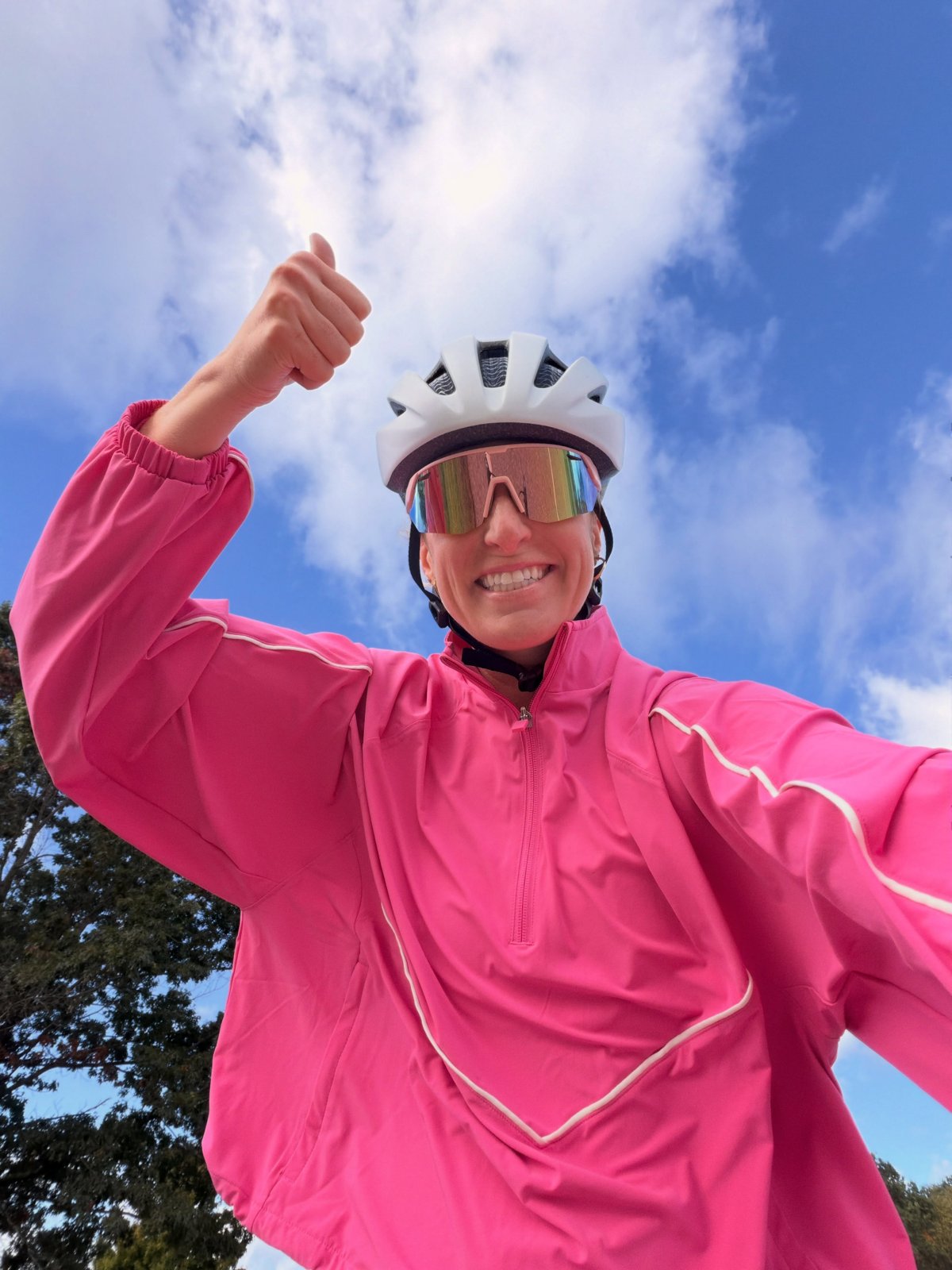 Sydney, founder of Girlie Biker Gang, giving a thumbs up in a pink jacket and bike helmet