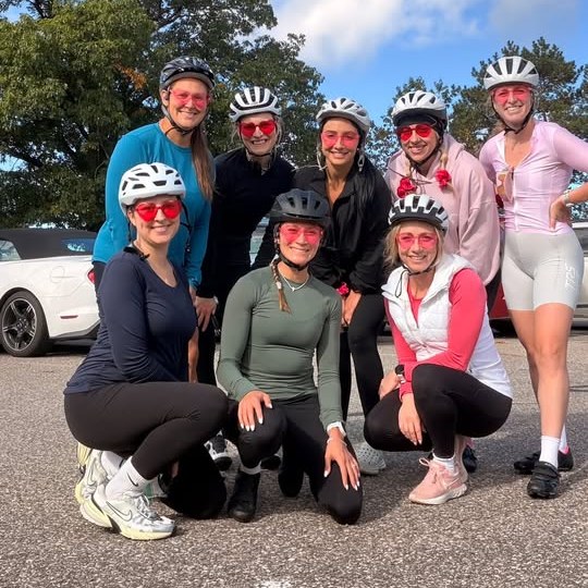 Nine Girlie Biker Gang riders in pink heart sunglasses smiling together