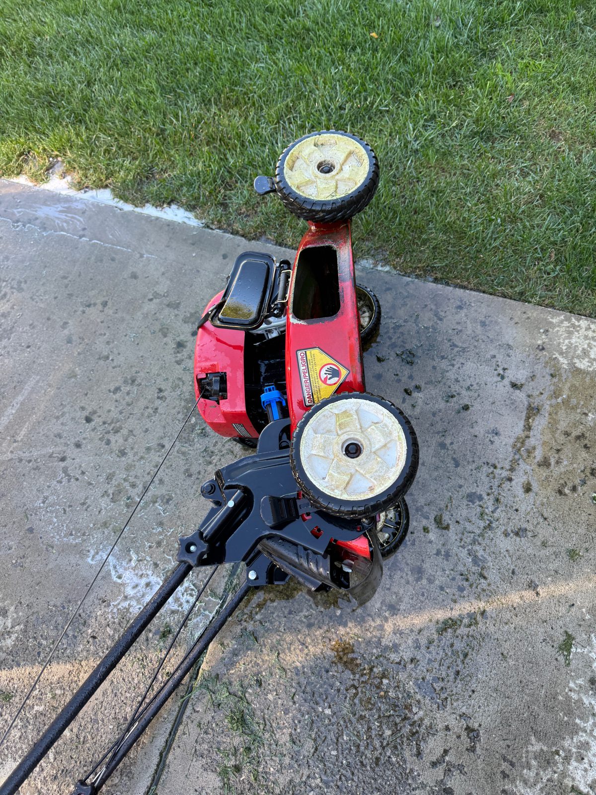 Walking mower cleaned and set on a driveway after its tune-up