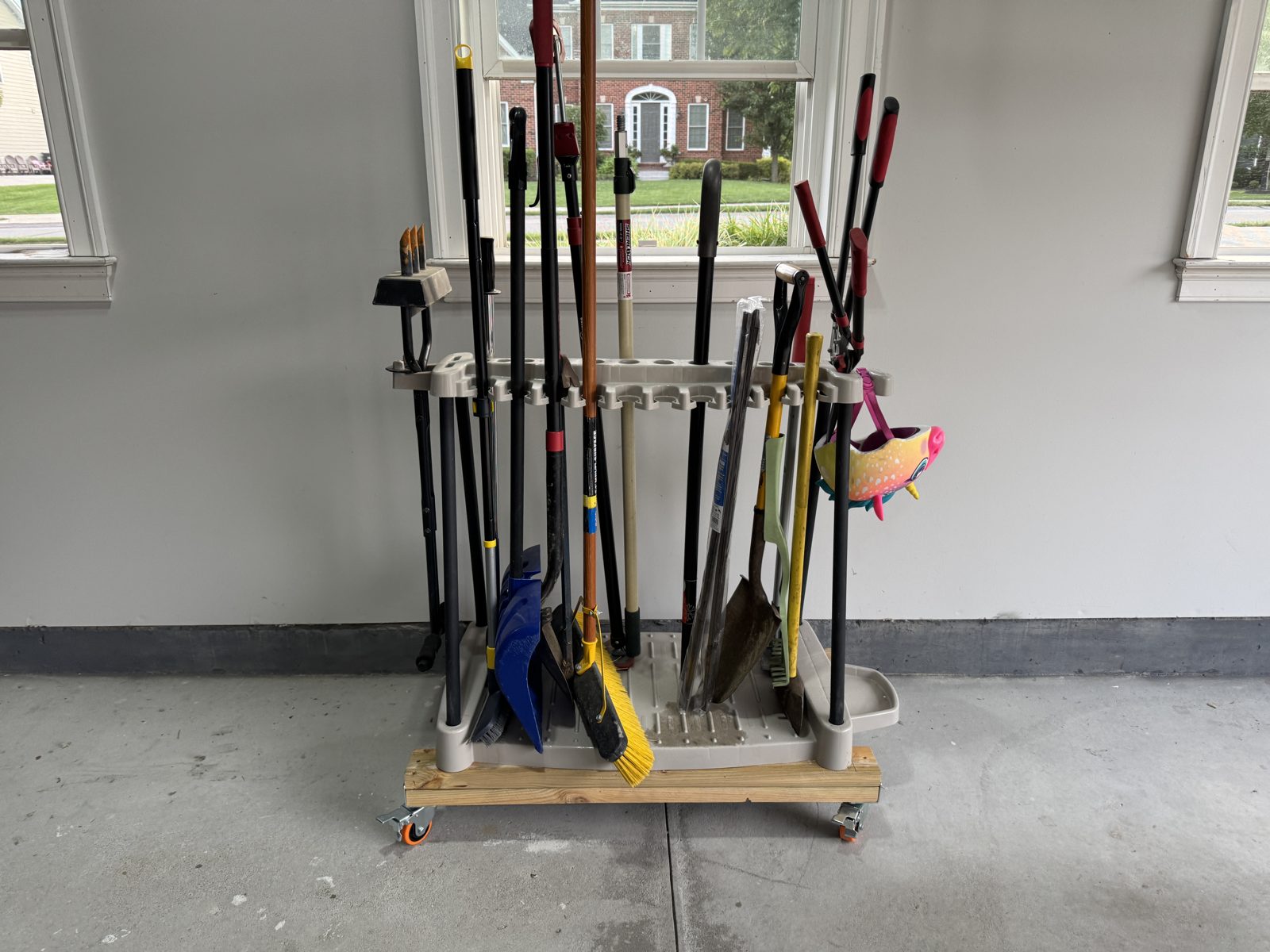 Rolling cart holding long yard tools in a garage