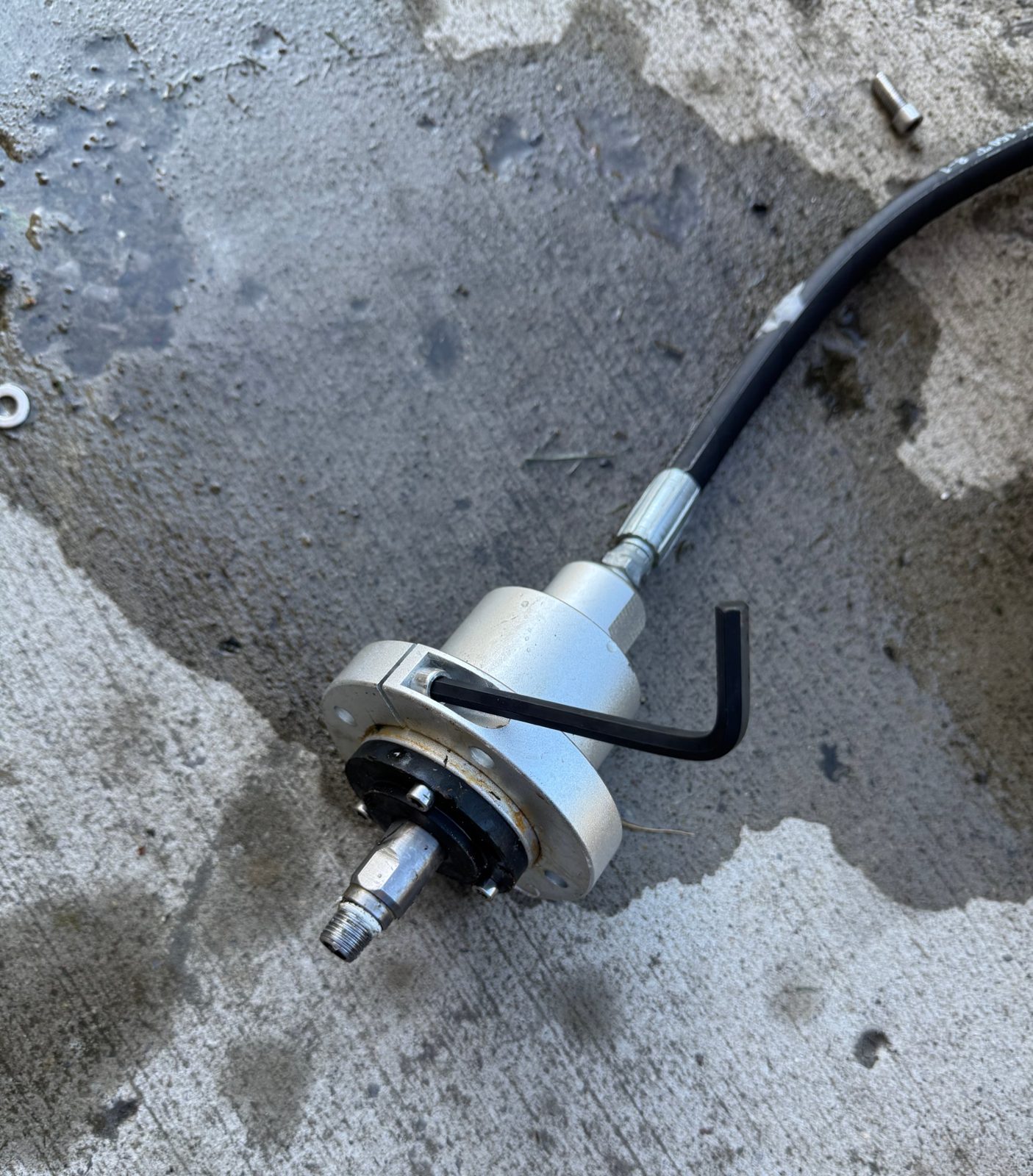 Swivel assembly taken apart on the driveway with a hex key in it and the high pressure hose attached