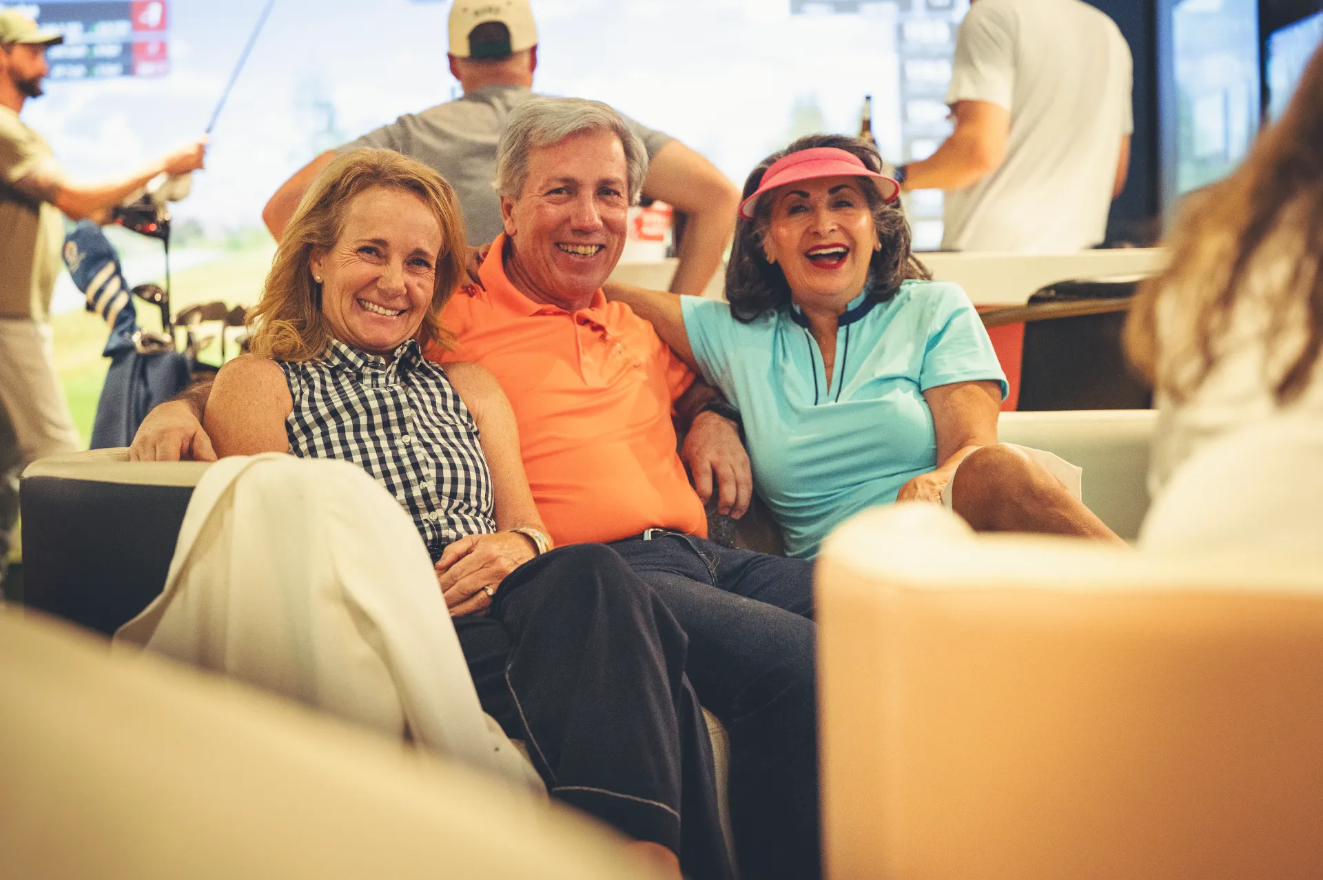 Group of friends laughing together on lounge seating at The PAR Club