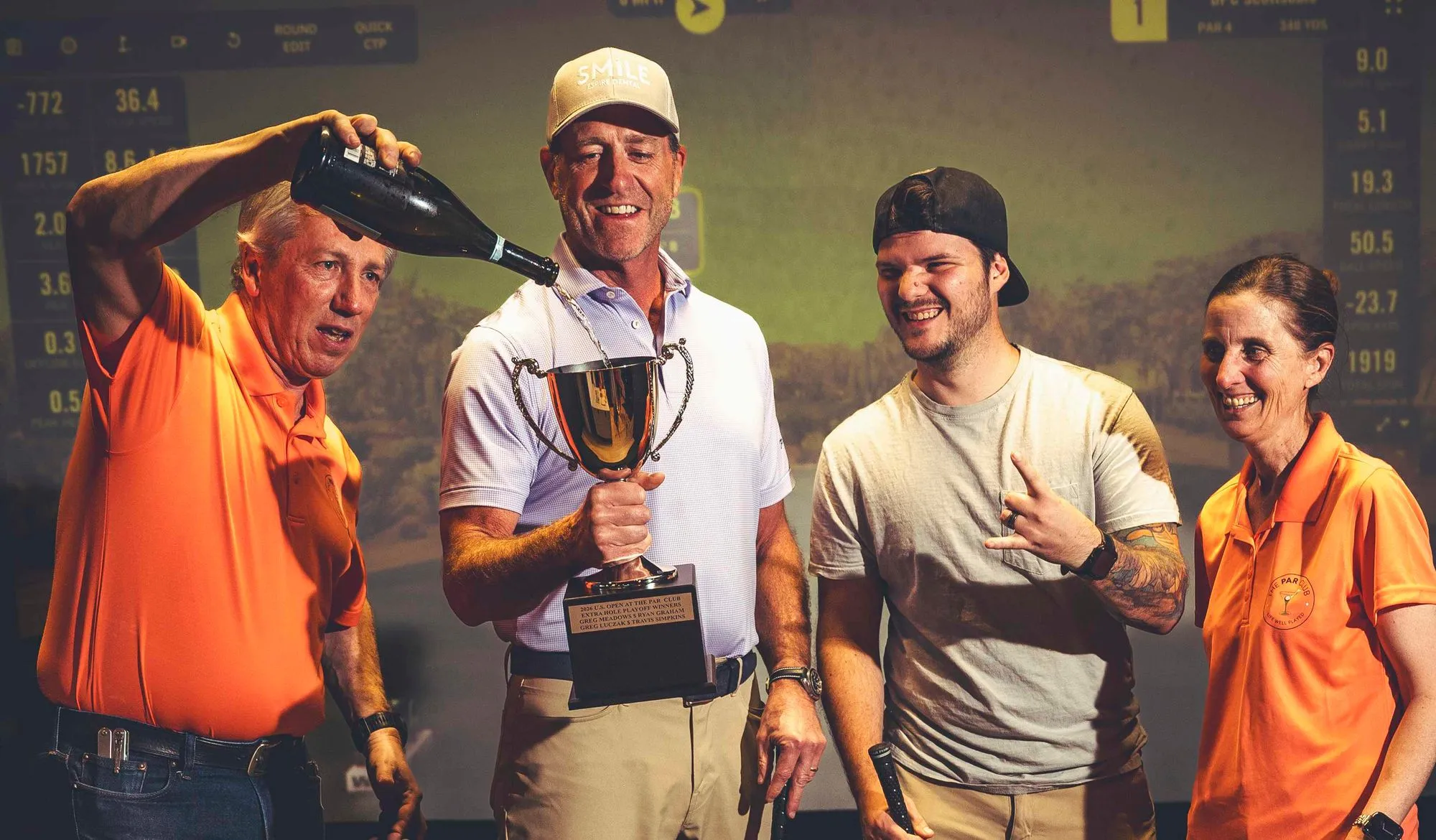 Group celebrating with a trophy and champagne after a golf tournament at The PAR Club