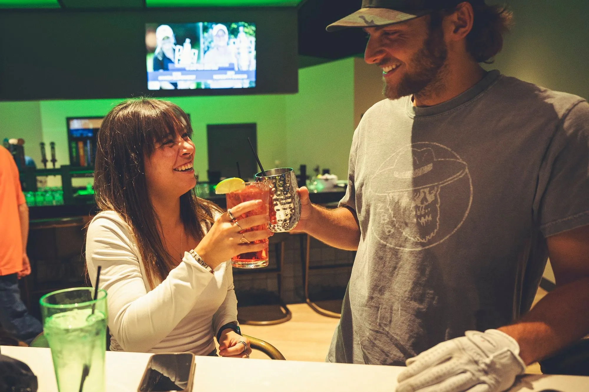Couple toasting cocktails at the bar at The PAR Club
