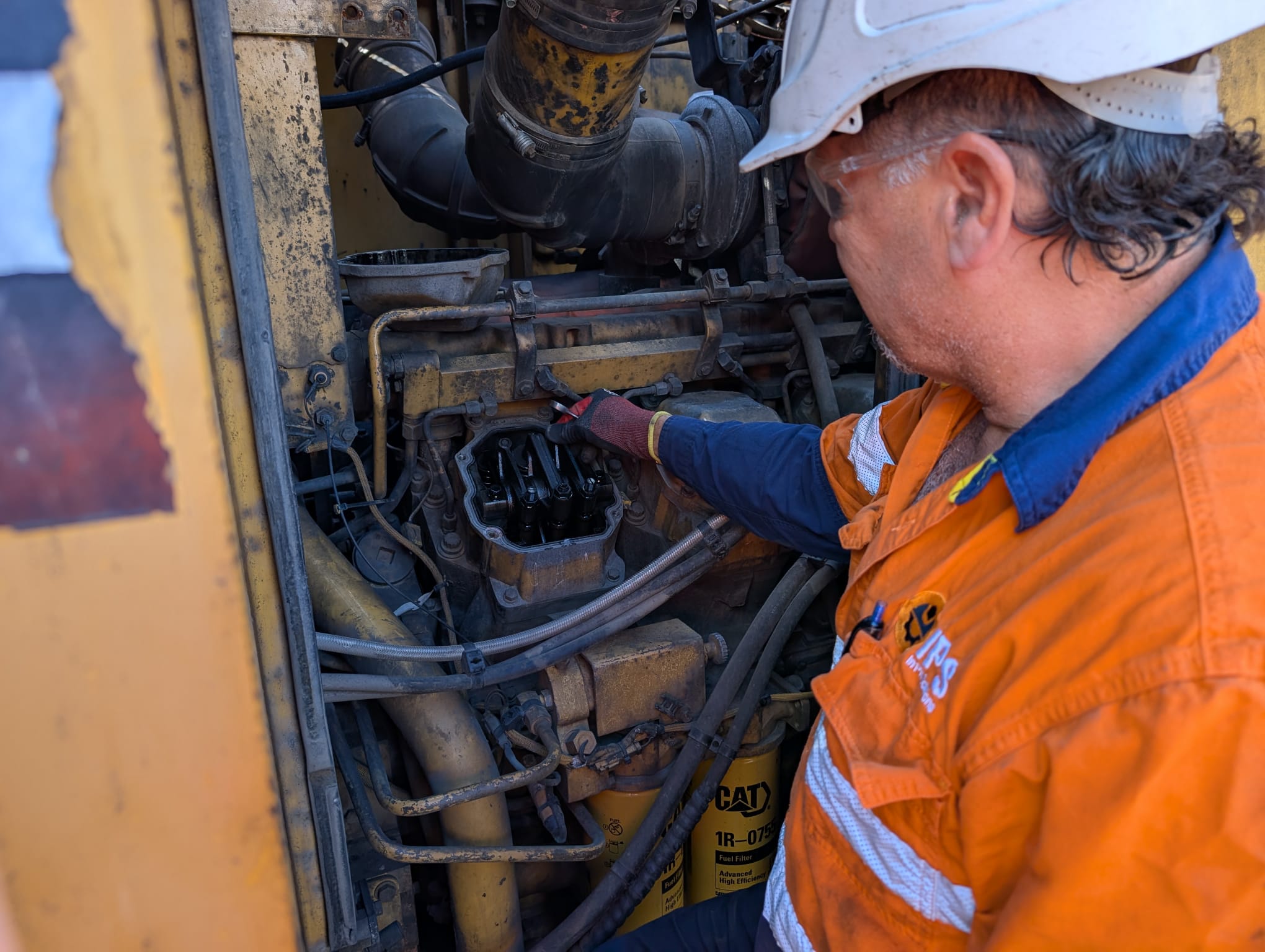 In Pit Solutions technician servicing CAT plant in full PPE