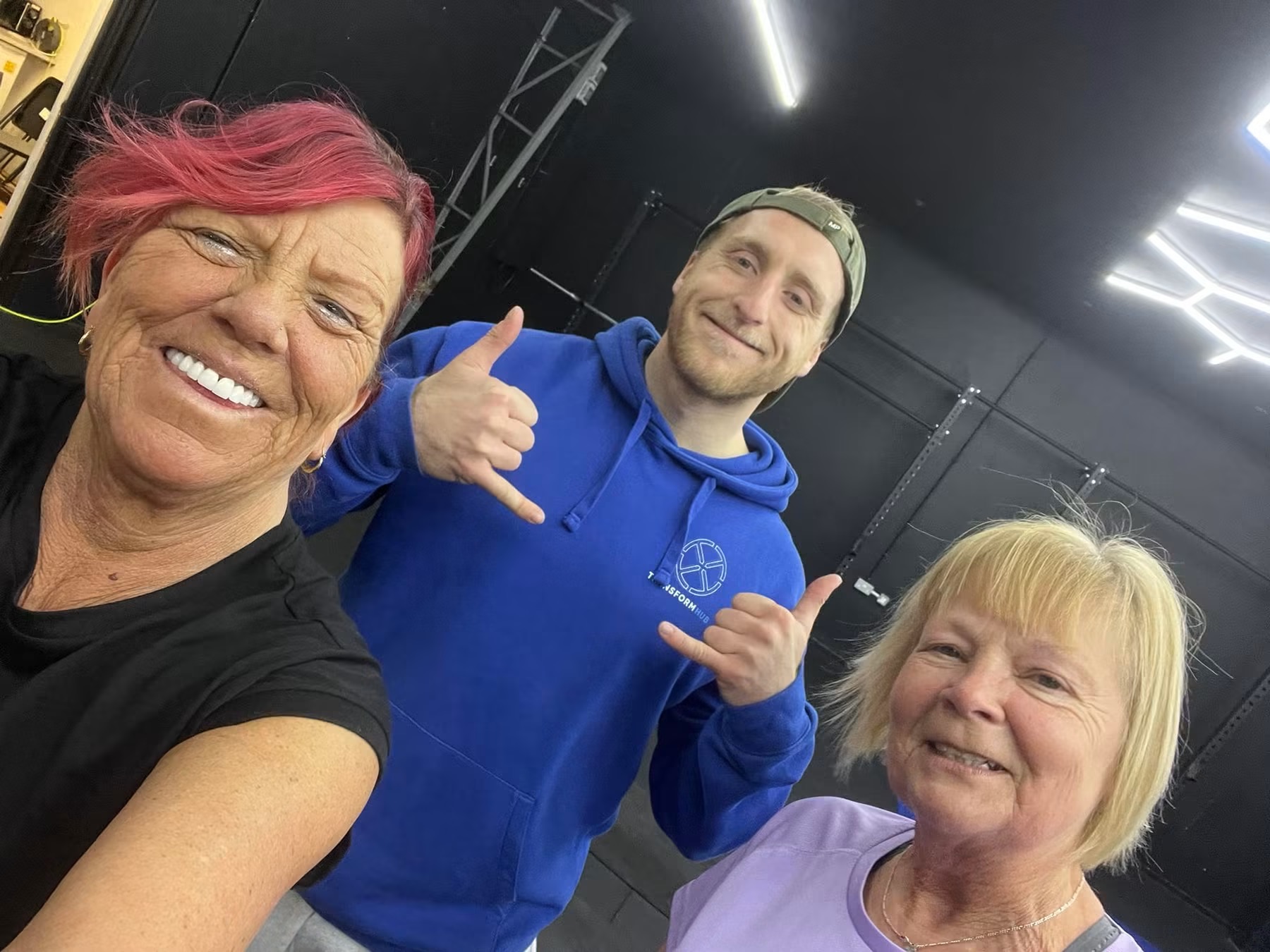 Women over 50 in our gym, smiling with one of our coaches