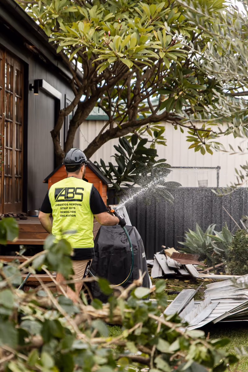 A man spraying down debris