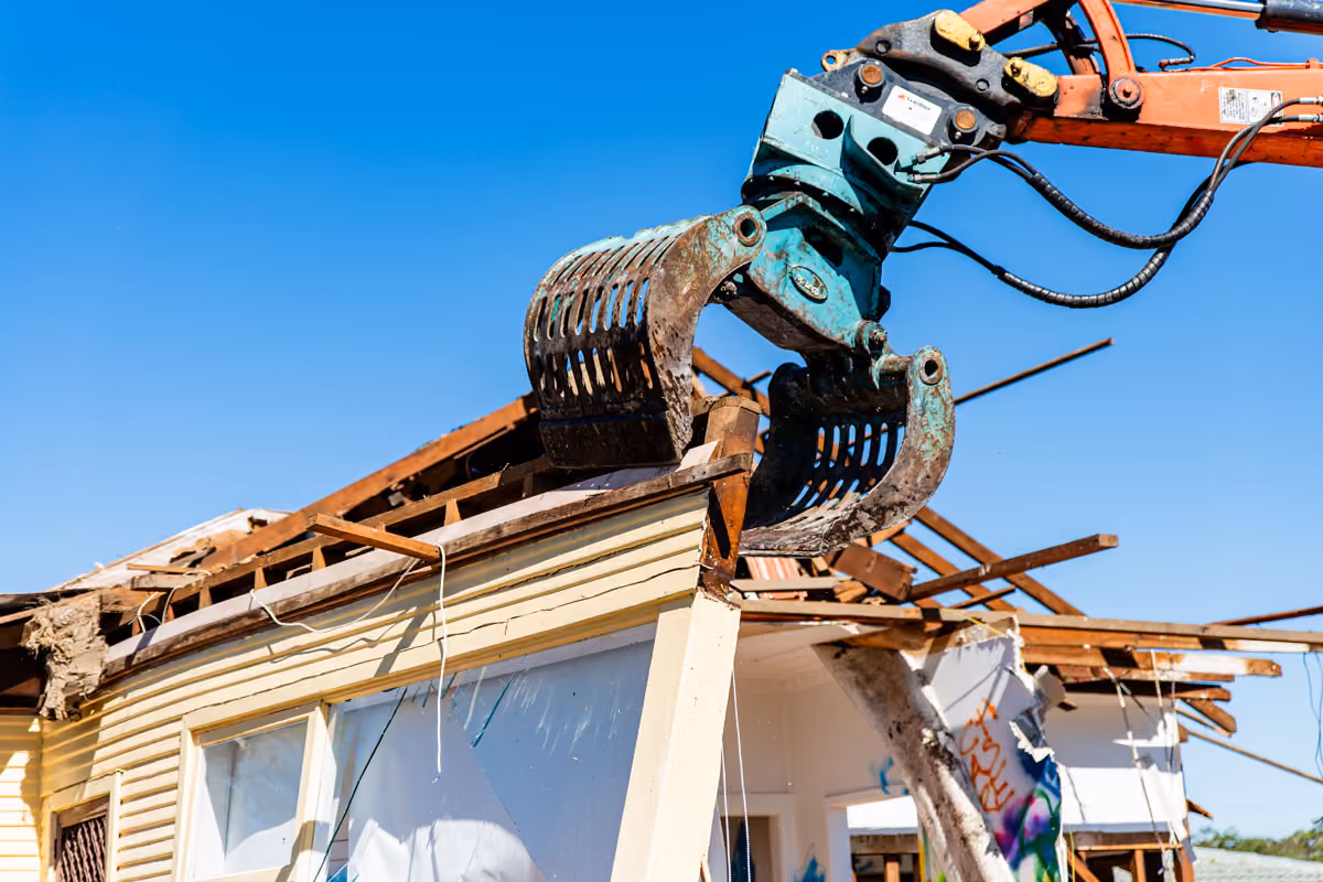 A bulldozer destroying a house