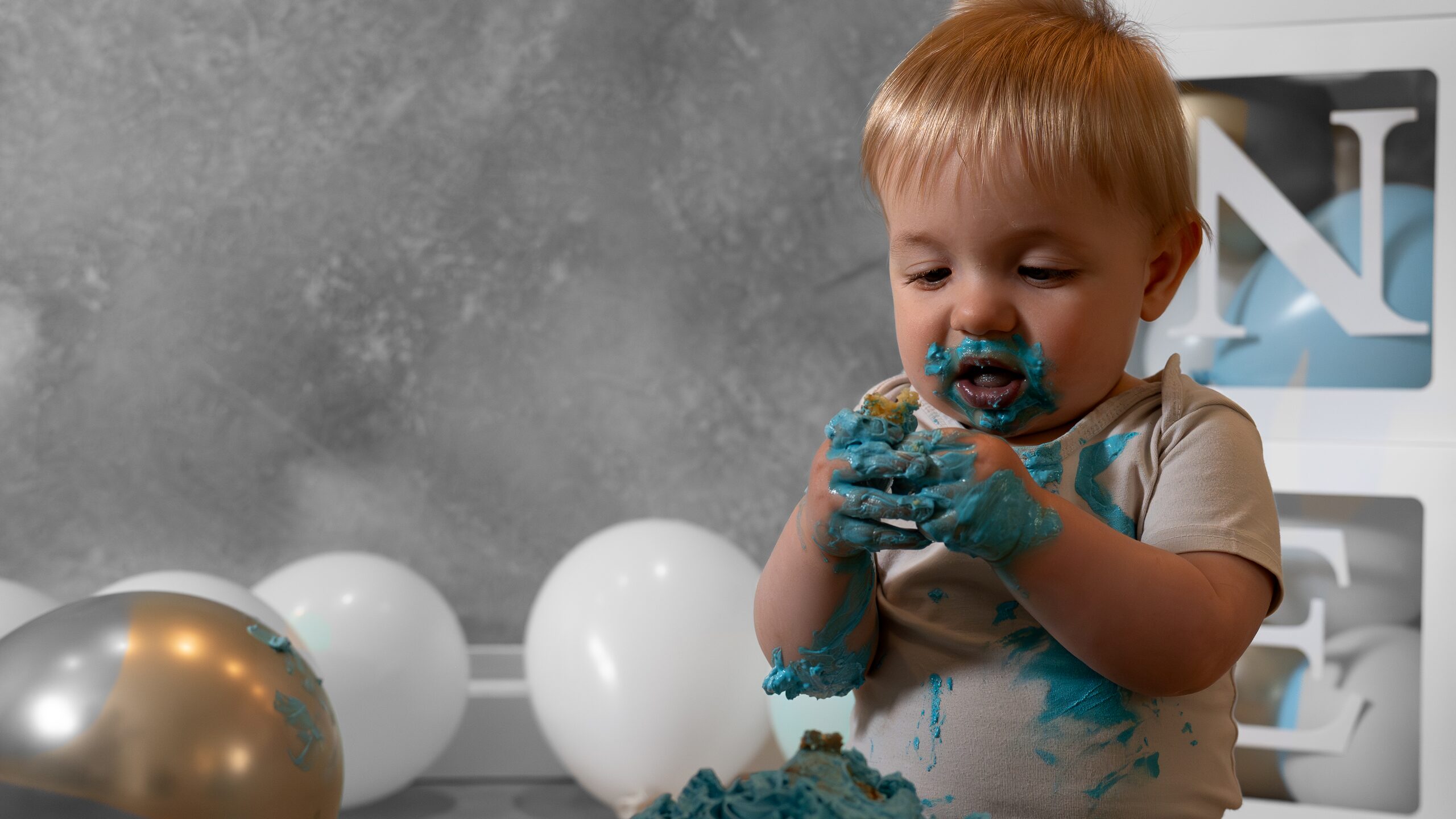 Jongen geniet van blauwe taart tijdens een cakesmashshoot in Drenthe