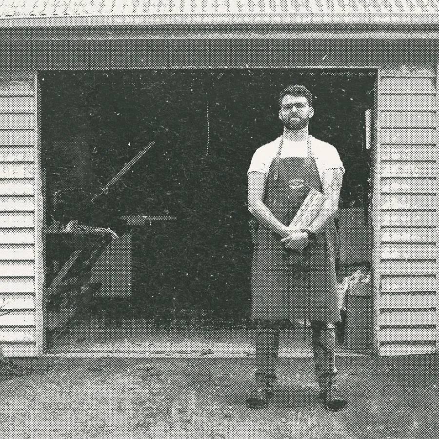 A man standing outside his garage screen printing workshop