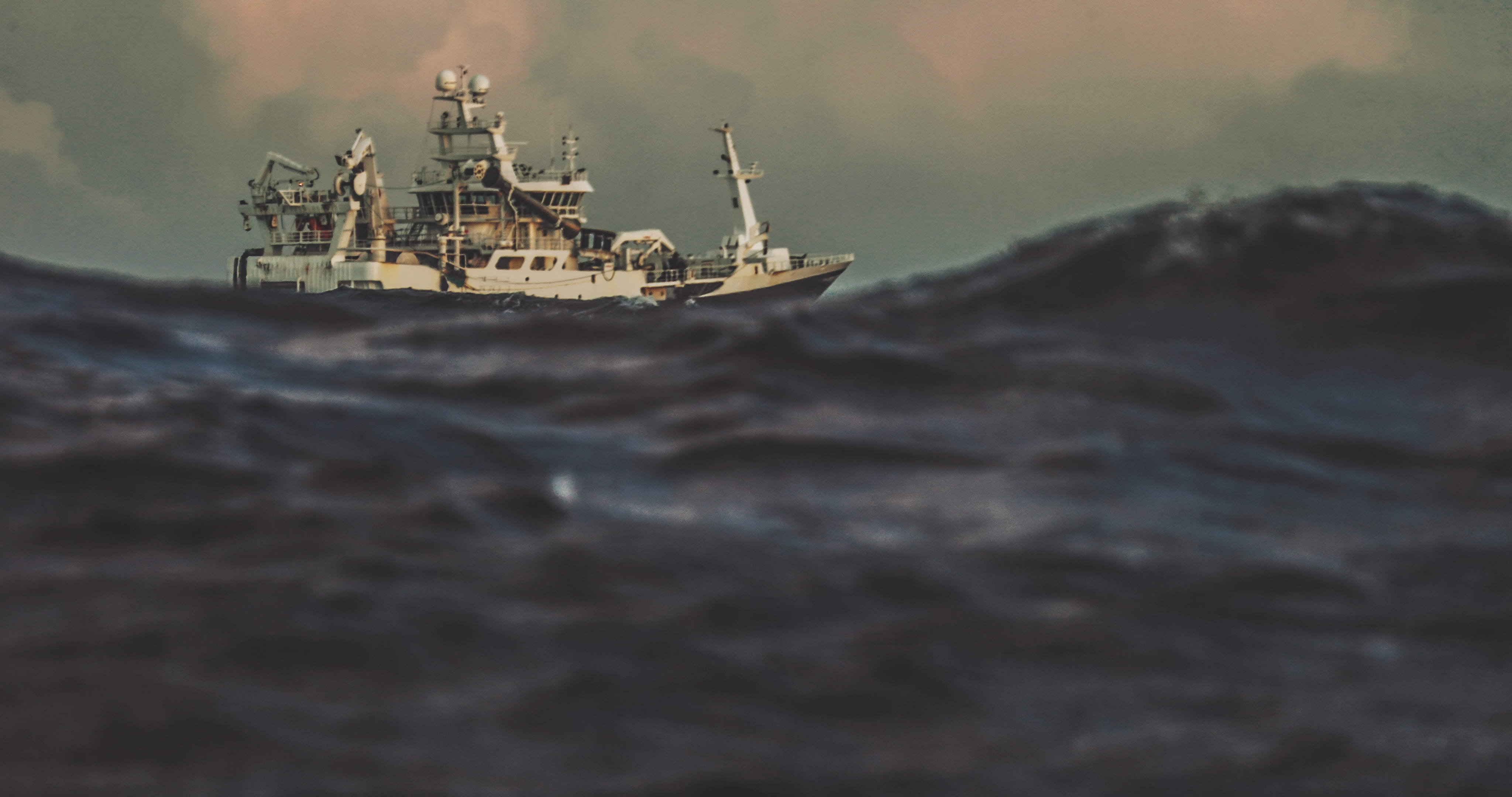 Offshore vessel navigating rough seas at dusk, symbolizing HELINOR Energy’s mission to enable zero-emission operations even in the most demanding maritime conditions.
