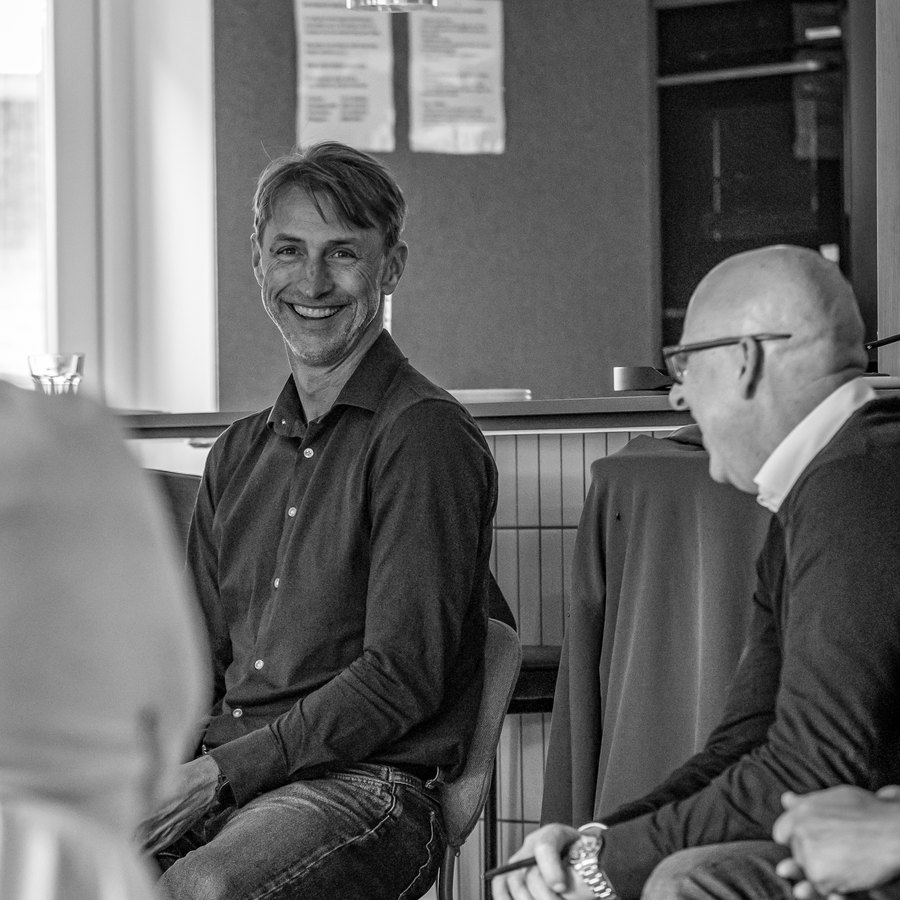 Jasper lachend in gesprek met een groep