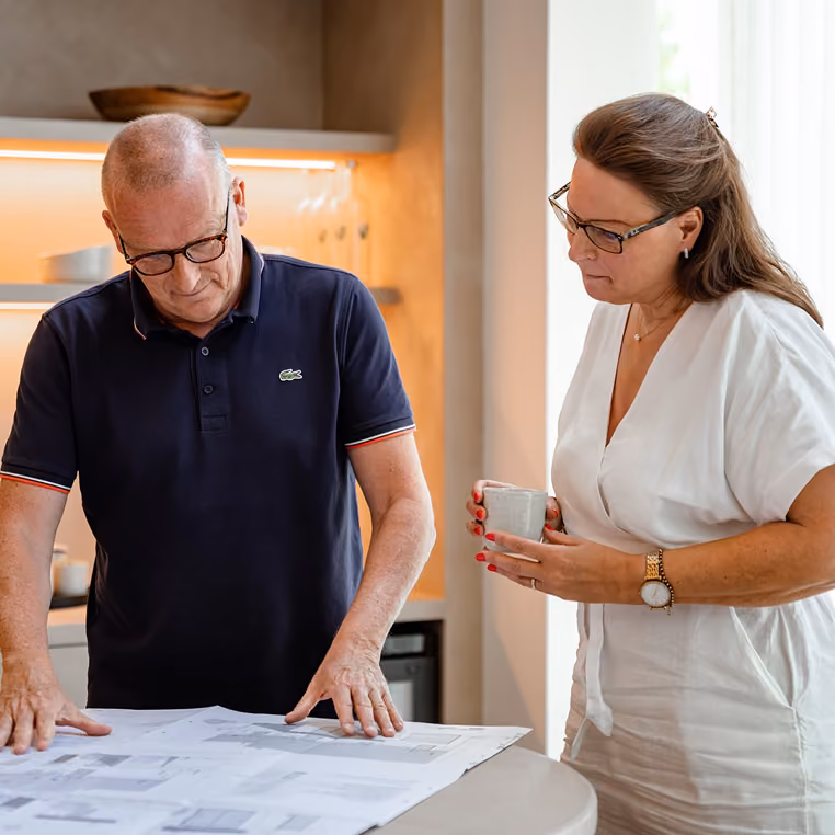 Two VGV Facades colleagues reviewing facade drawings together at a showroom table.