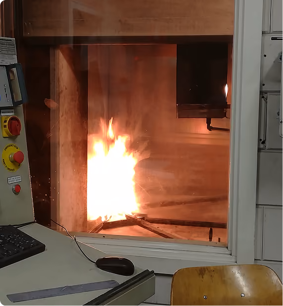 Flames inside a fire-test furnace during fire resistance testing of a facade assembly.
