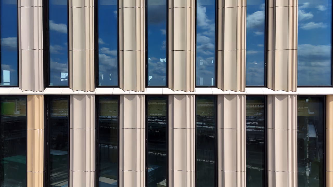 Close-up of the Dordthuis facade, with rounded cream columns alternating with dark reflective glazing.