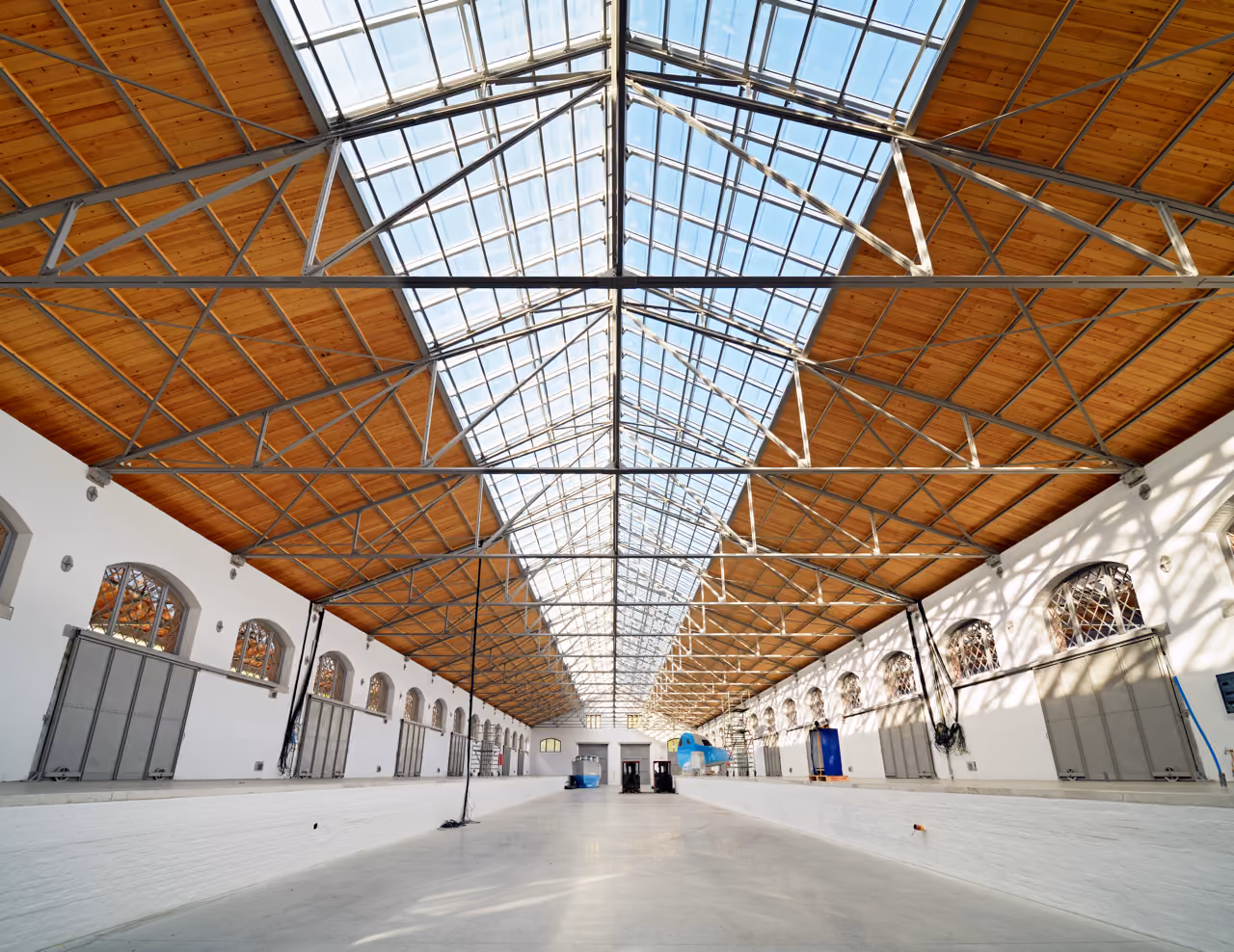 Interior of the Douaneloods, a long hall lit through a central skylight in its timber roof structure.