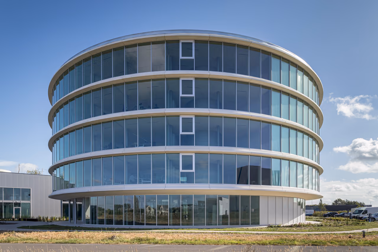 The Ekopak headquarters, an oval office building wrapped in horizontal bands of glazing.