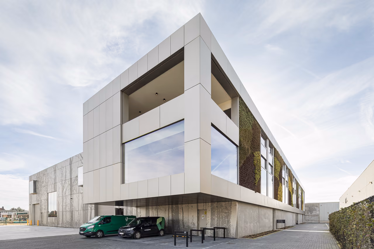 The Evergreen building in white concrete, with a large square opening framing a terrace.