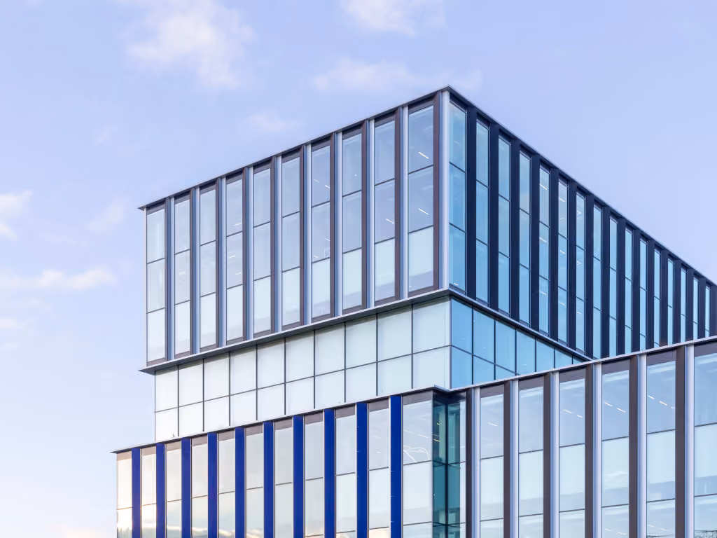 Corner of the Hogeschool Inholland building, fully glazed with blue-toned spandrel panels.