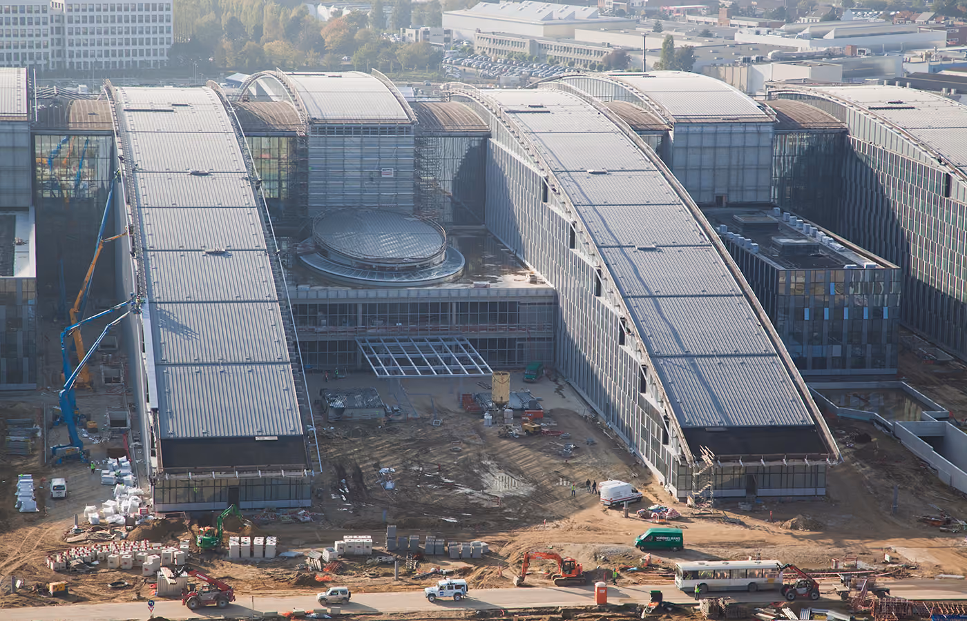 The NATO headquarters under construction, its curved roofs spanning the site between cranes.