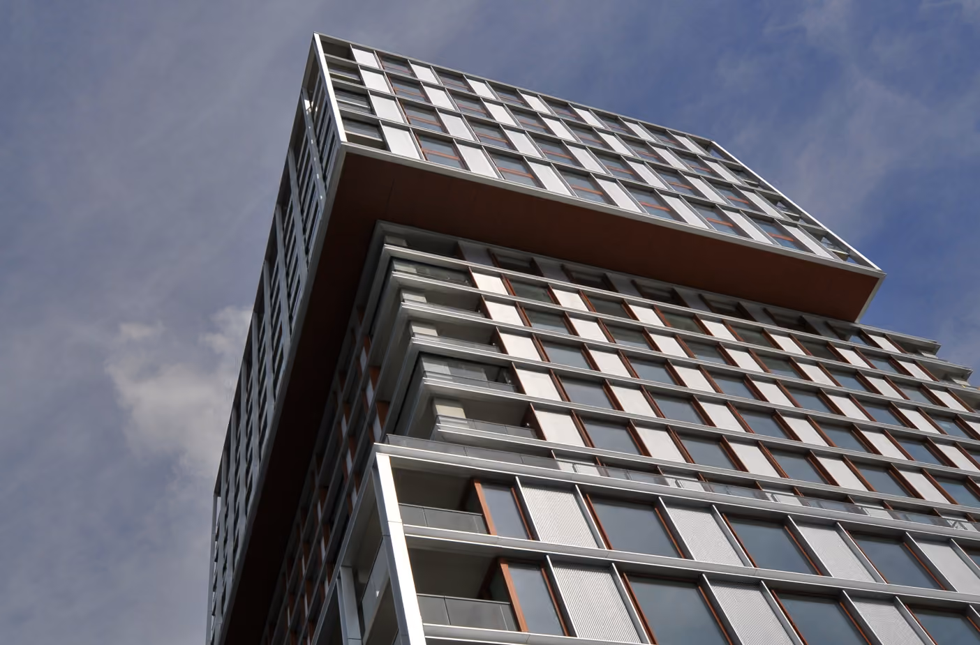 Piekstraat tower seen from below, with a dark grid facade of glass and metal panels.