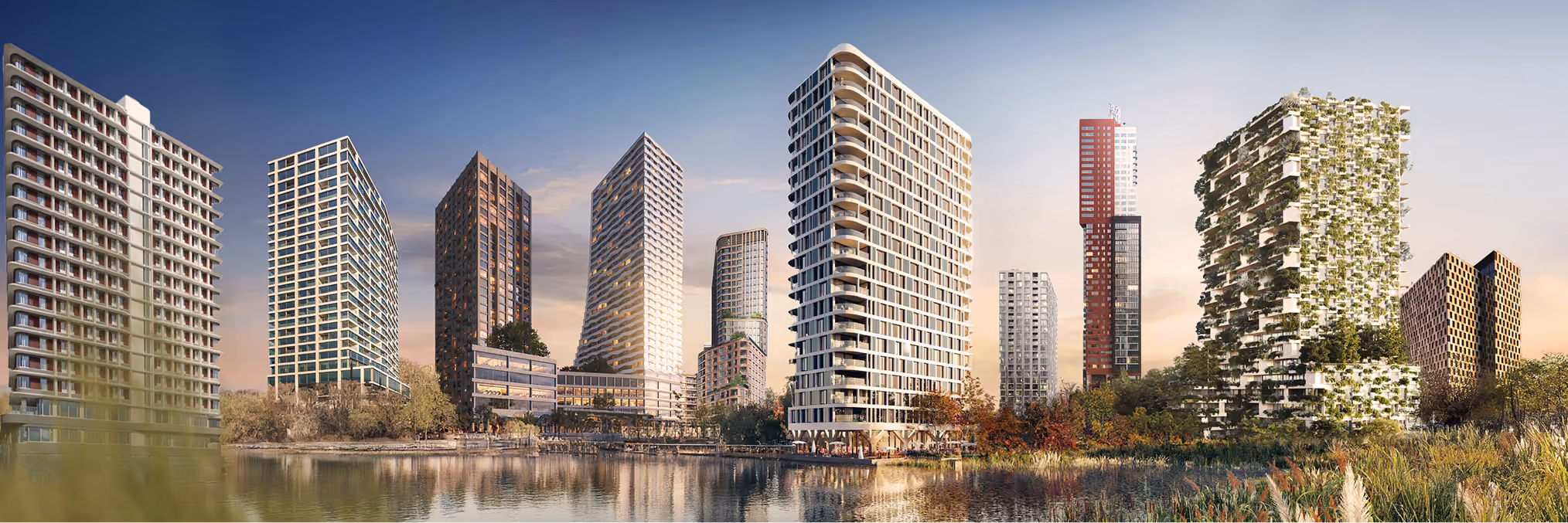 Panoramic view of a modern city skyline featuring diverse high-rise buildings including glass towers, a white curved residential building, a red tower under construction, and a green façade building with plants growing on its balconies, all reflected in a calm body of water in the foreground during sunset.