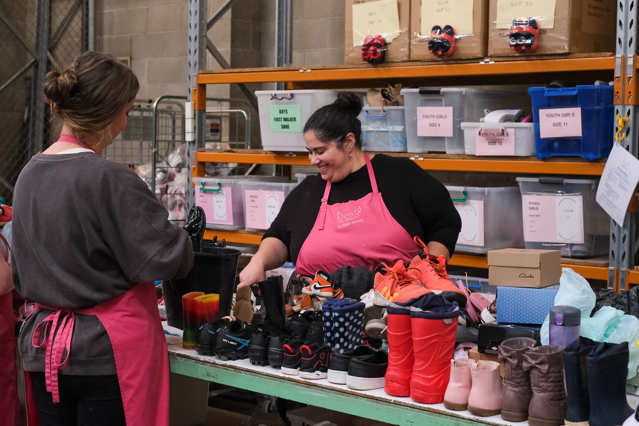 Smiling woman volunteers to sort donated goods