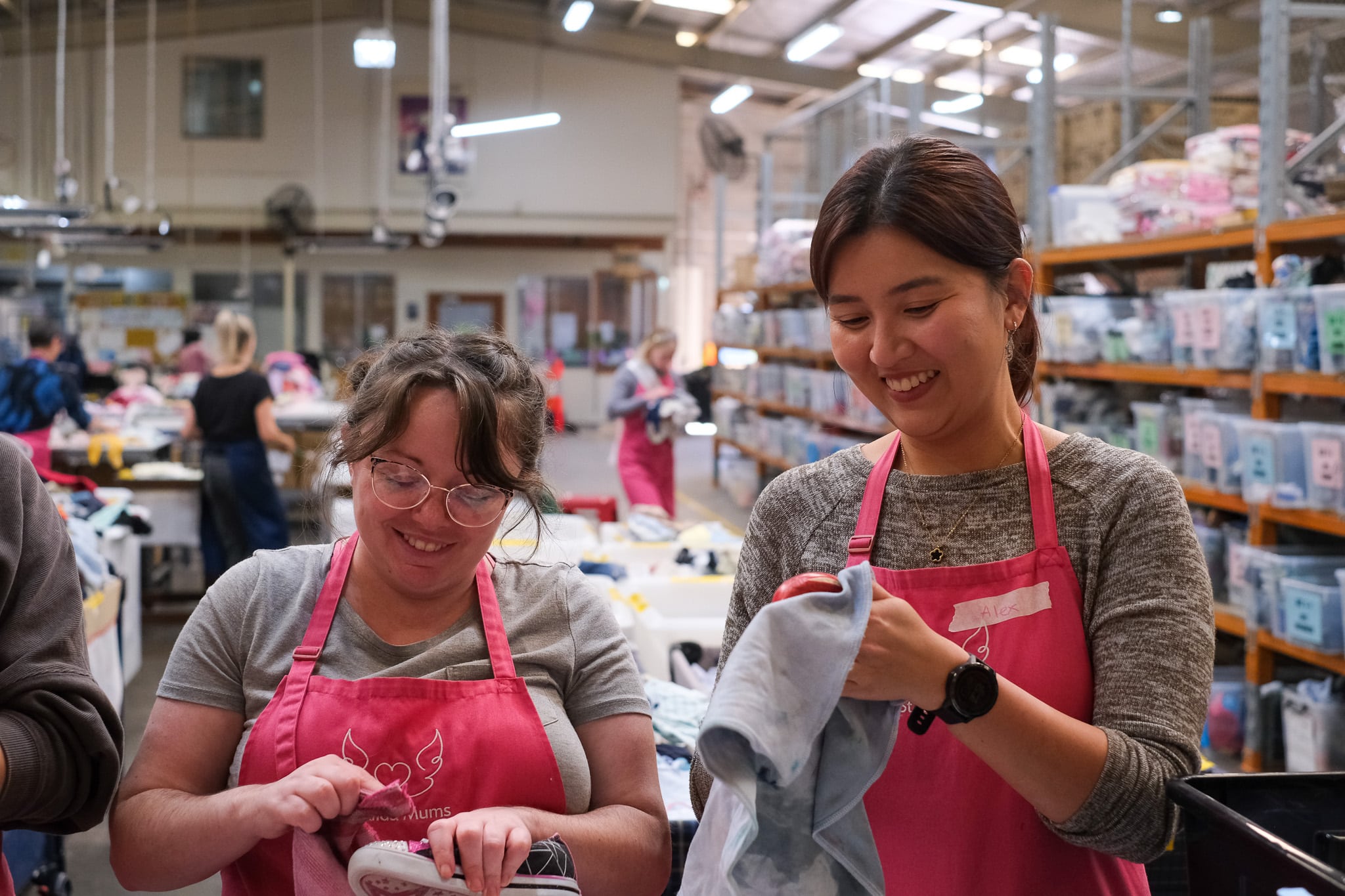 Smiling colleagues volunteer to clean donated goods