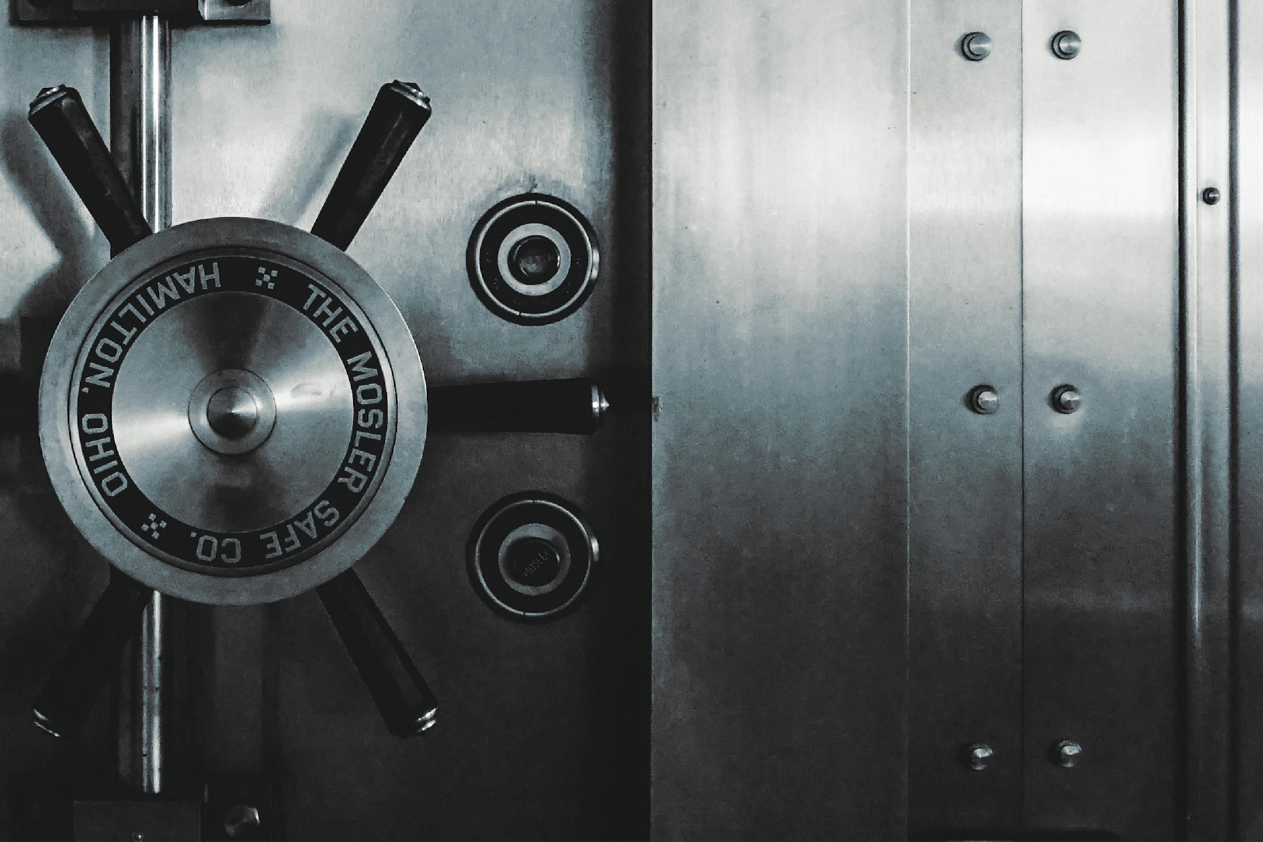 Combination dial and handle on a steel vault door.