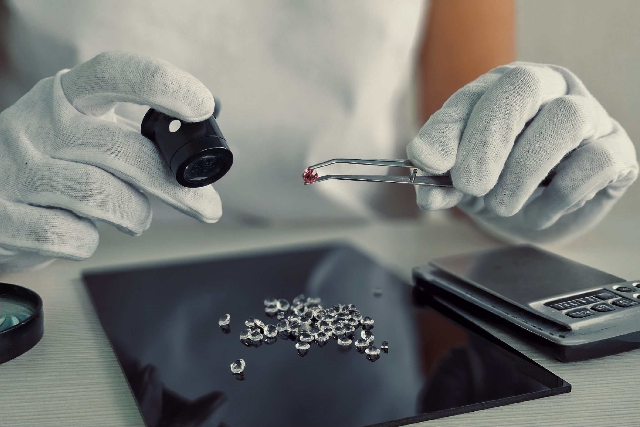 Gloved hands examining metal samples with tweezers.