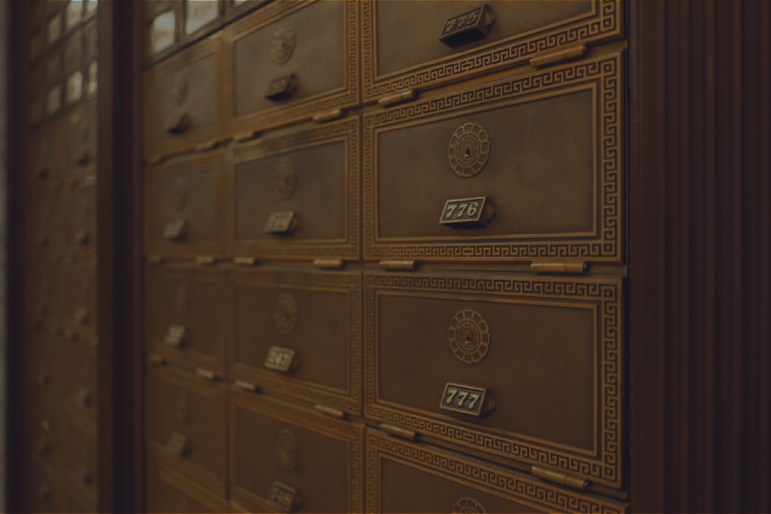 Ornate brass deposit box fronts in a vault hall.