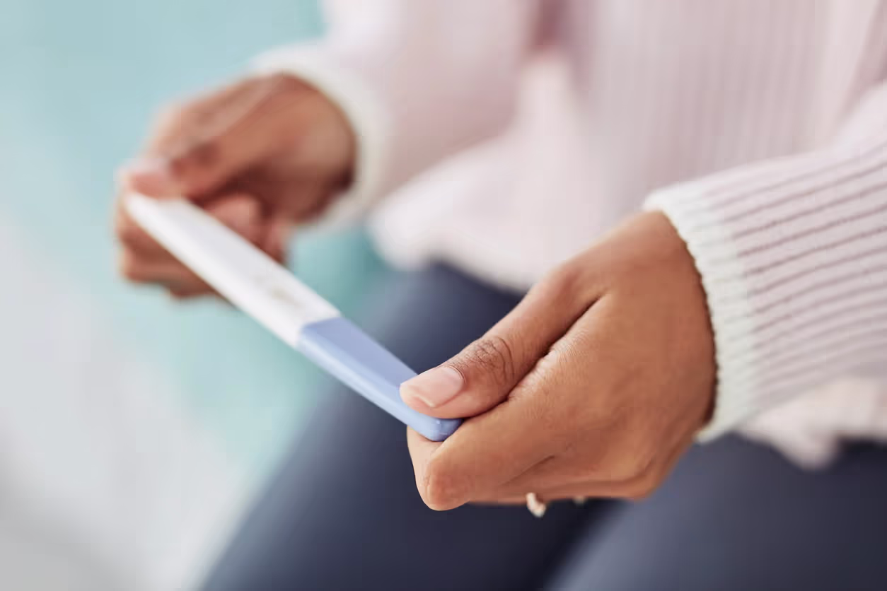 Close-up of a woman's hands holding a pregnancy test.