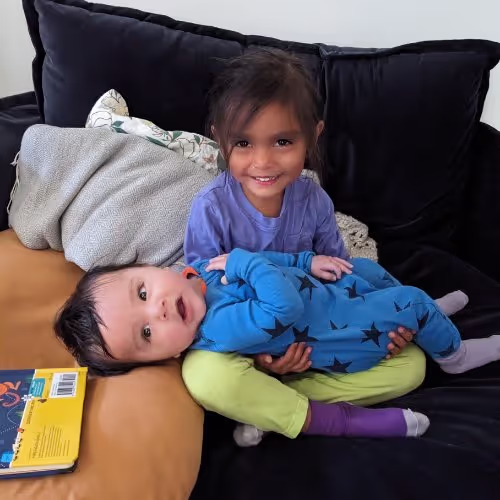 Tiny Health toddler holding baby sibling