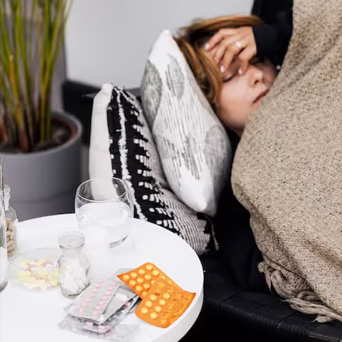 Sick woman laying down on a couch, dealing with histamine intolerance