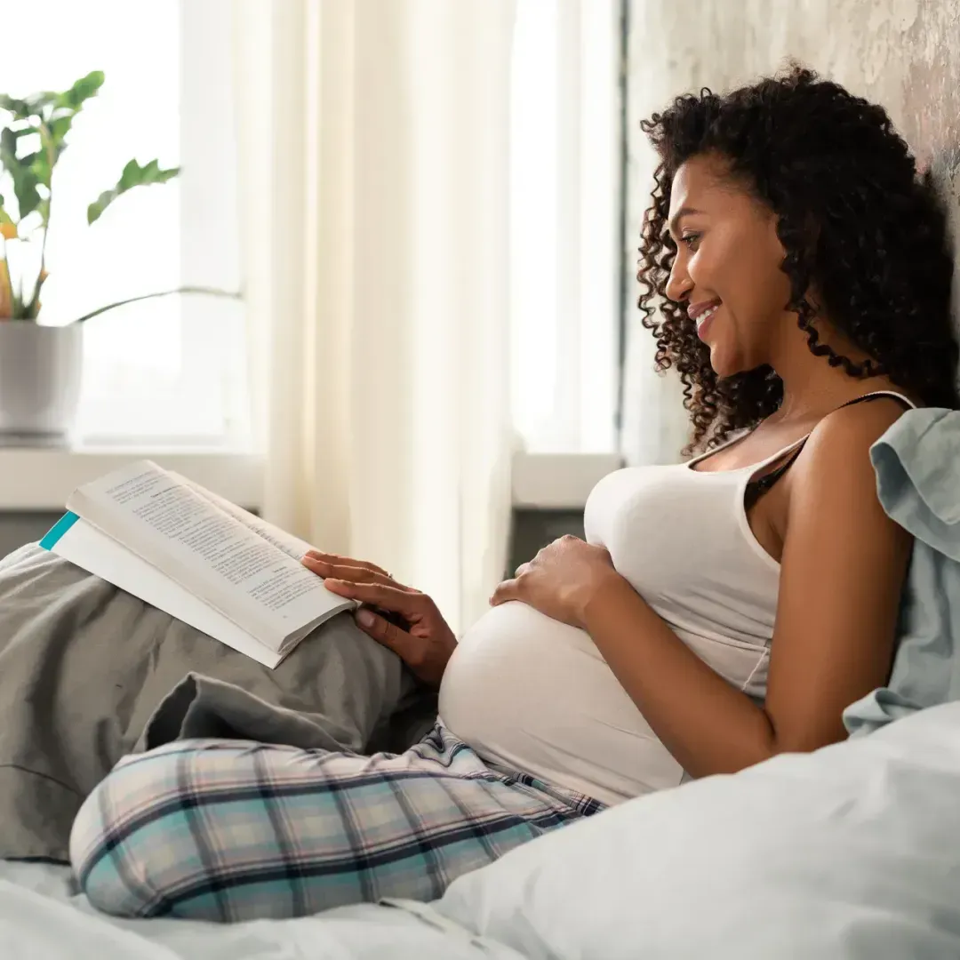 Pregnant woman reading a book about gestational diabetes meal planning