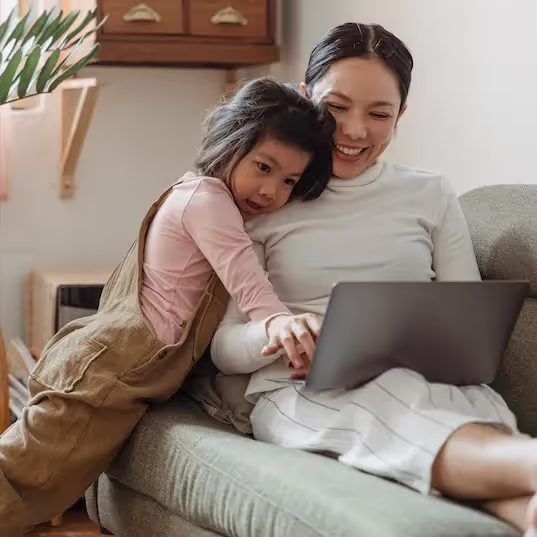 A mother and her child on a couch researching probiotic supplements for the family