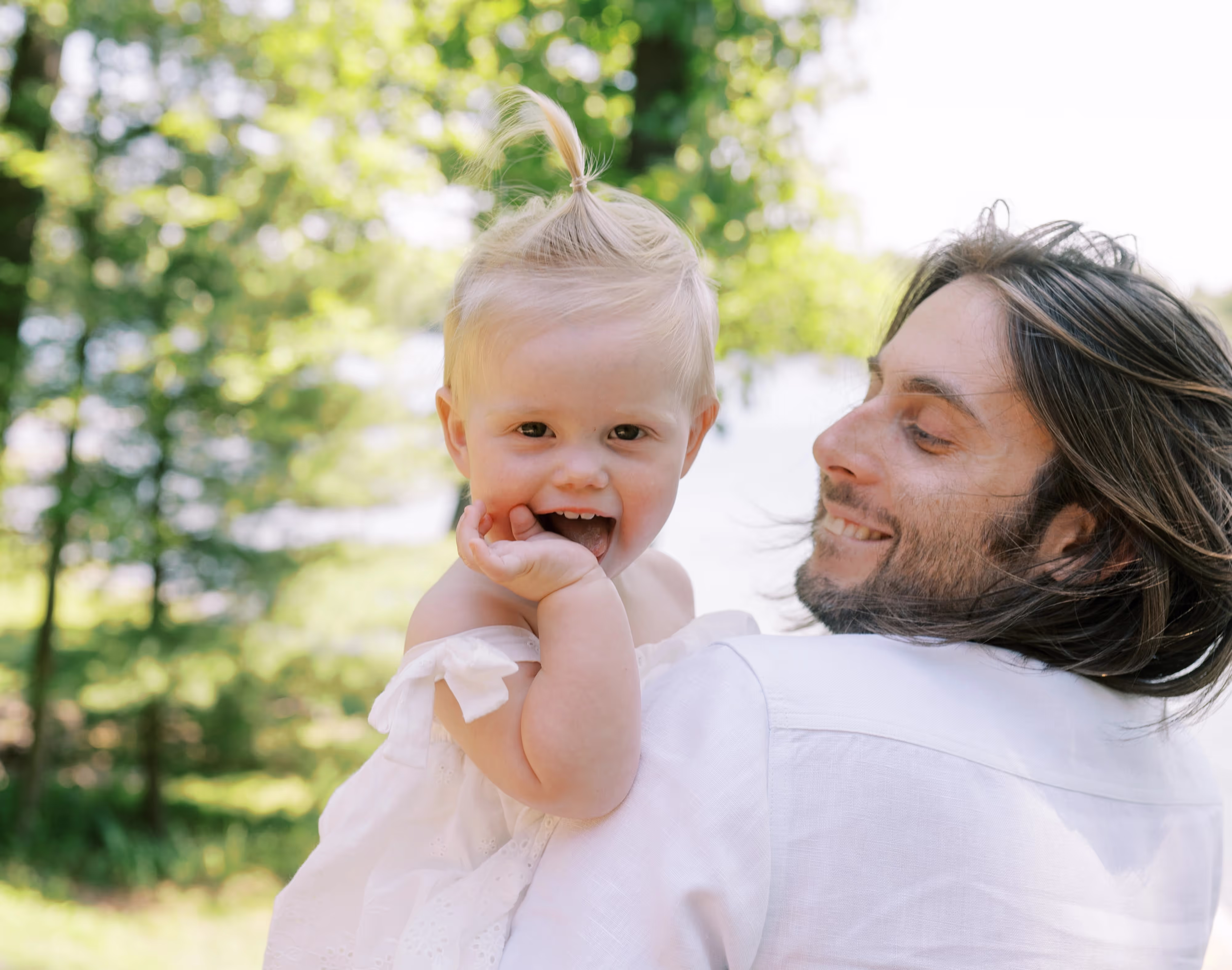 A father holding his infant daughter outdoors