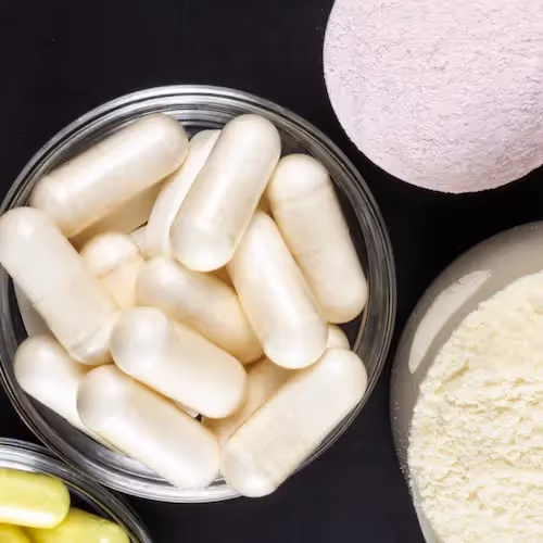 Probiotic powder and capsules in bowls, highlighting supplements that support gut microbiome health and overall wellness.